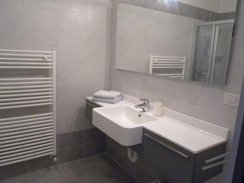 リーヴァ・デル・ガルダにあるSole Riva apartmentのバスルーム(白い洗面台、鏡付)