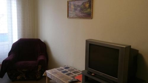 エカテリンブルクにあるАпартаменты на Азина 20 к2のリビングルーム(テレビ、椅子付)