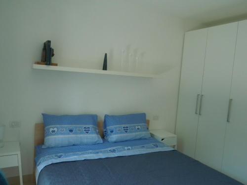 リーヴァ・デル・ガルダにあるSole Riva apartmentのベッドルーム1室(青いベッド1台、青い枕付)