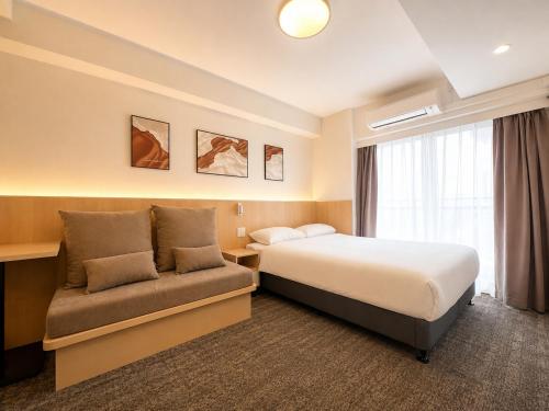a hotel room with a bed and a couch at Hotel Arashi Nippombashi 1 No006 in Osaka