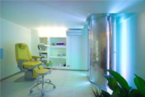 a room with a yellow chair and a refrigerator at Casa Roby 120 mt Beach in Fontane Bianche
