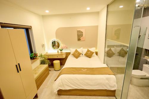 a bedroom with a bed and a glass shower at Maison Boutique Hotel - Bình An in Phước Lộc Xã