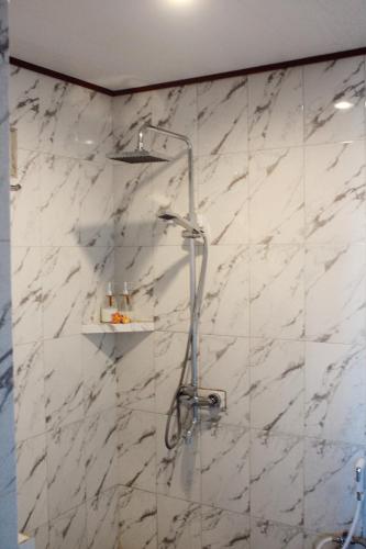 a shower in a bathroom with a marble wall at STHANATAPA HILL's in Sidemen