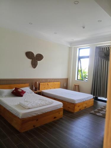 a bedroom with two beds and a window at Homestay Kim Thuy in Hiếu Xương