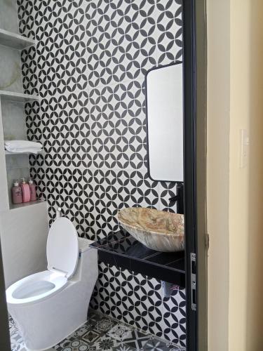a bathroom with a toilet and a black and white wall at Homestay Kim Thuy in Hiếu Xương