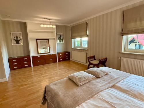 a bedroom with a large bed and wooden floors at Baltic Garden Villa in Gdynia