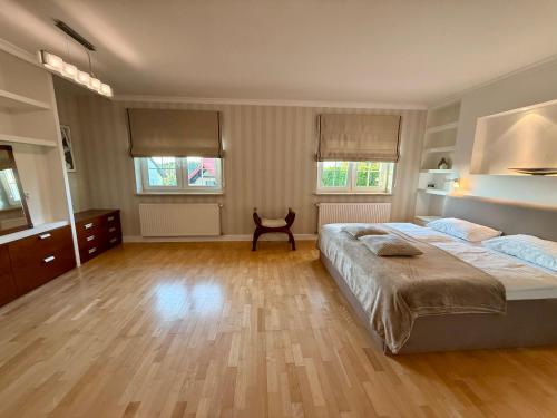a large bedroom with a large bed and wooden floors at Baltic Garden Villa in Gdynia