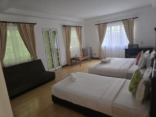 a hotel room with two beds and a couch at 5 Twenty @ Ampang Hilir in Kuala Lumpur