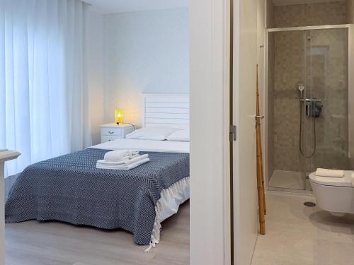 a bedroom with a bed and a bathroom with a shower at Dani's House - Nazaré in Nazaré