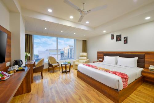 a hotel room with a bed and a desk and a window at Ginger Jammu , Bari Bramhana in Jammu