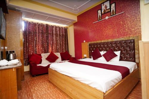 a bedroom with two beds and a red wall at Hotel King Palace in Shimla
