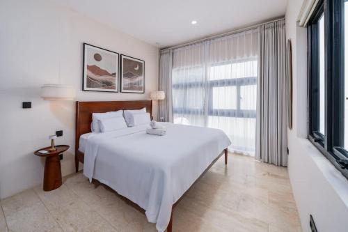 a bedroom with a white bed and a large window at Modern 1BR with Spacious Living Room in Uluwatu