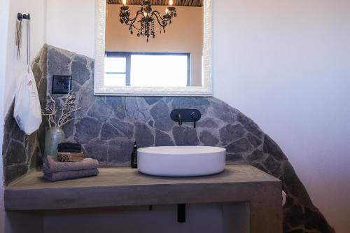 a bathroom with a sink and a mirror at 3 ALOES GUESTHOUSE in Uis