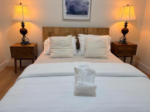 a bedroom with a white bed with two night stands at Guest Suite in Mission in Mission