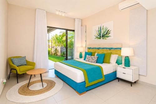 a bedroom with a king sized bed and a chair at SALTA apartment l Complex Ocean terraces in Poste Lafayette