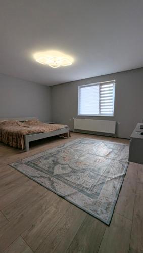 an empty room with two beds and a rug at Хата над гуком in Kosiv