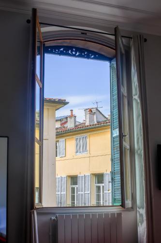 une fenêtre ouverte avec vue sur un bâtiment dans l'établissement L'Oustau D'Alberta, à Aix-en-Provence