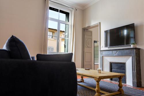 a living room with a fireplace and a tv at L'Oustau D'Alberta in Aix-en-Provence