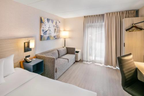 a hotel room with a bed and a couch at Comfort Inn Sydney - Cape Breton in Sydney