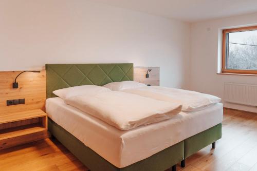 a bedroom with a large bed with a green headboard at Frankenfelsberg in Oedrotte
