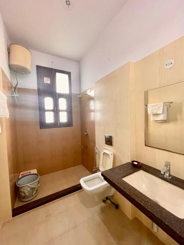 a bathroom with a sink and a toilet and a mirror at ZenRoofs-3 BHK Bungalow in Jaipur