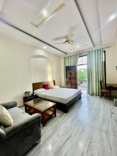 a hotel room with a bed and a couch at ZenRoofs-3 BHK Bungalow in Jaipur