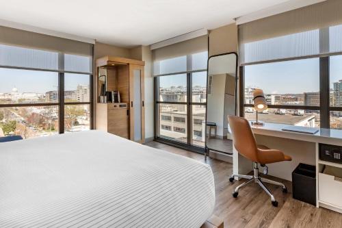 a bedroom with a large bed and a desk with a chair at Cambria Hotel Washington DC Navy Yard Riverfront in Washington, D.C.