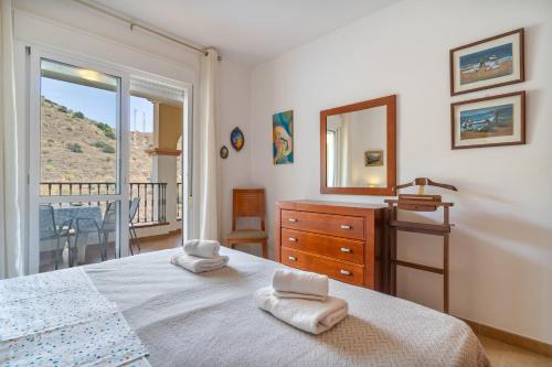 a bedroom with a bed and a dresser and a mirror at Apartment Mountain View Torrox town in Torrox