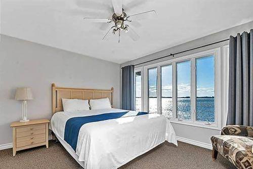 a bedroom with a bed and a large window at Isaiah Tubbs Resort & Conference Centre in Picton