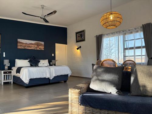 a bedroom with a bed and a couch at 3 ALOES GUESTHOUSE in Uis