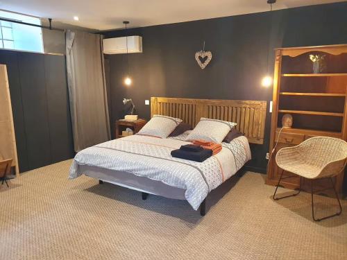 a bedroom with a bed and a chair at La Pastorale in Nyons