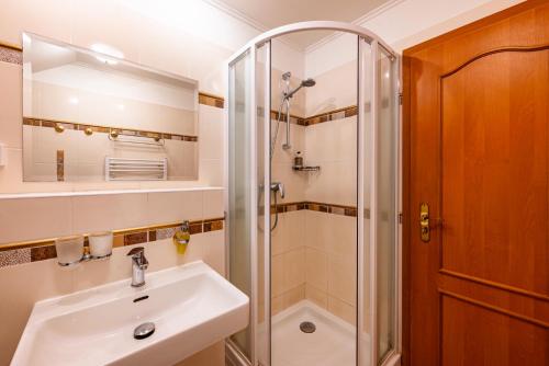 a bathroom with a sink and a shower at B&B Villa Hotel in Mariánské Lázně