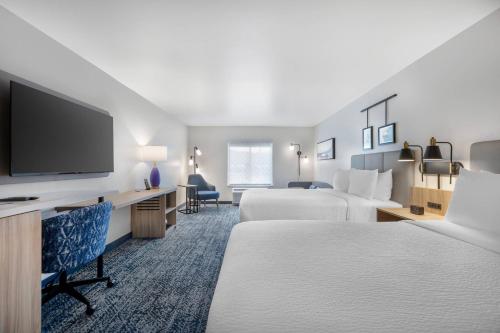 a hotel room with two beds and a flat screen tv at Sleep Inn & Suites Henderson - Las Vegas in Henderson