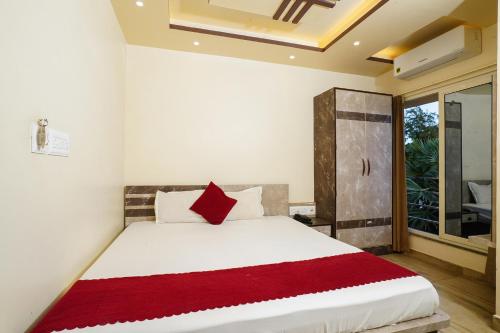 a bedroom with a large bed with a red pillow at Hotel Sea Wood in Digha