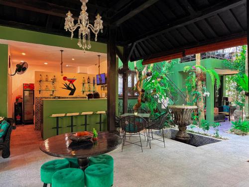 a living room with a table and chairs and a chandelier at The Lodge Canggu in Tumbak Bayuh