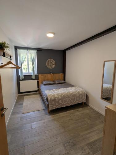 a bedroom with a bed and a wooden floor at Le nid de cigognes in Menchhoffen