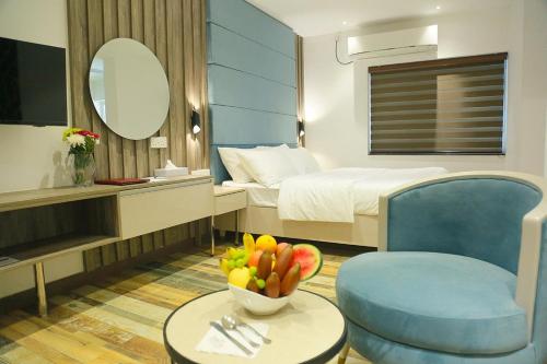 a hotel room with a bed and a bowl of fruit on a table at Sri Suryas Hotel in Colombo