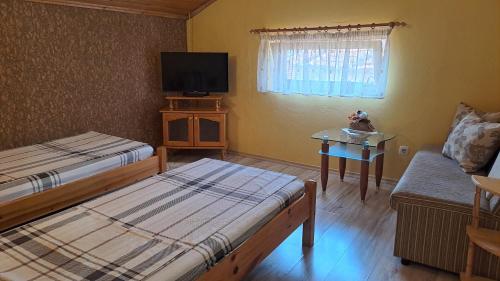 a room with two beds and a tv and a couch at Geto Apartment in Belogradchik