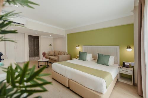 a bedroom with a large bed and a living room at Roseum Boutique Hotel in Larnaca