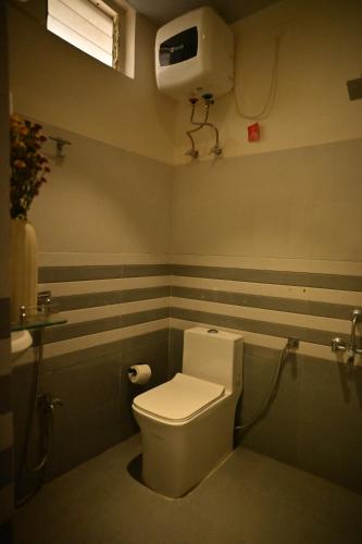 a bathroom with a white toilet in a room at Noi Homes - Entire 2BHK Luxury Flat with Parking, Kitchen and Balcony in Jorhat