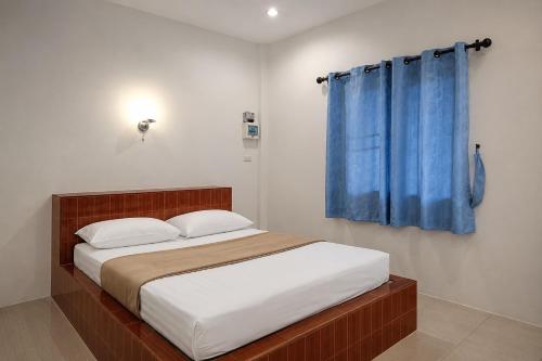 a bedroom with a bed with a blue curtain at 169 Home Resort in Ban Huai Khram