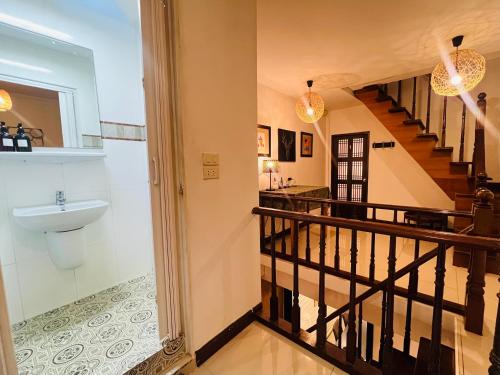 ein Badezimmer mit Waschbecken und Treppe in der Unterkunft La Locanda in Bangkok
