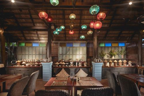 a restaurant with wooden tables and chairs and lights at Maison Dalabua in Luang Prabang