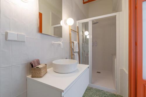 a white bathroom with a sink and a shower at Raízes 22 - Apartamento 6 in Puebla de Don Fadrique