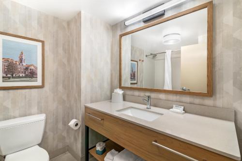 a bathroom with a sink and a toilet and a mirror at Hampton Inn Schenectady Downtown in Schenectady