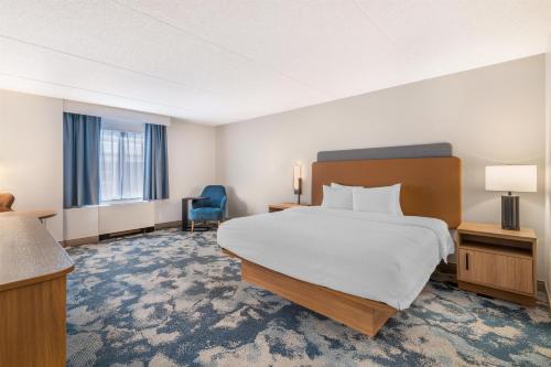 a hotel room with a bed and a blue chair at Hampton Inn Schenectady Downtown in Schenectady