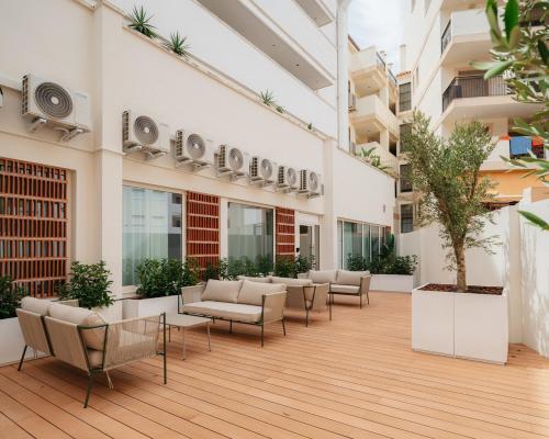 an empty courtyard of a building with chairs and tables at Hostal Serea in Denia