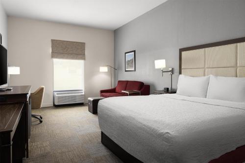 a hotel room with a bed and a red chair at Hampton Inn Morristown in Morristown