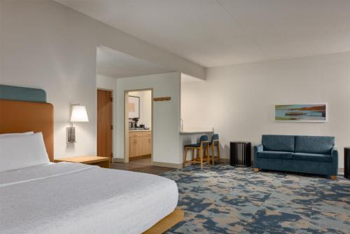 a hotel room with a bed and a desk and chairs at Hampton Inn Springfield-South in Springfield