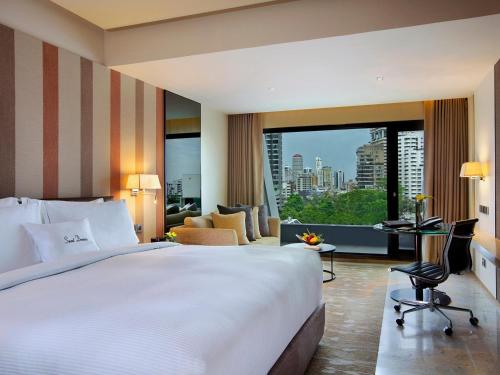 a hotel room with a large bed and a desk at DoubleTree by Hilton Sukhumvit Bangkok in Bangkok